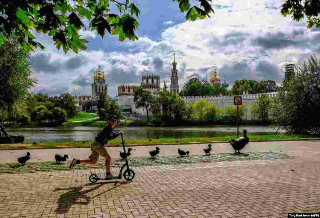 A boy rides a scooter near the Novodevichy Convent in central Moscow. (AFP/Yuri Kadobinov)