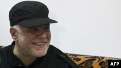Iraqi Prime Minister Haidar al-Abadi smiles during a meeting with military commanders in the al-Tayaran neighborhood of Mosul on July 9.