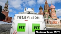 Мәскеуде Кремльдің фонында тұрған Russia Today телеарнасының логотипі (Көрнекі сурет)