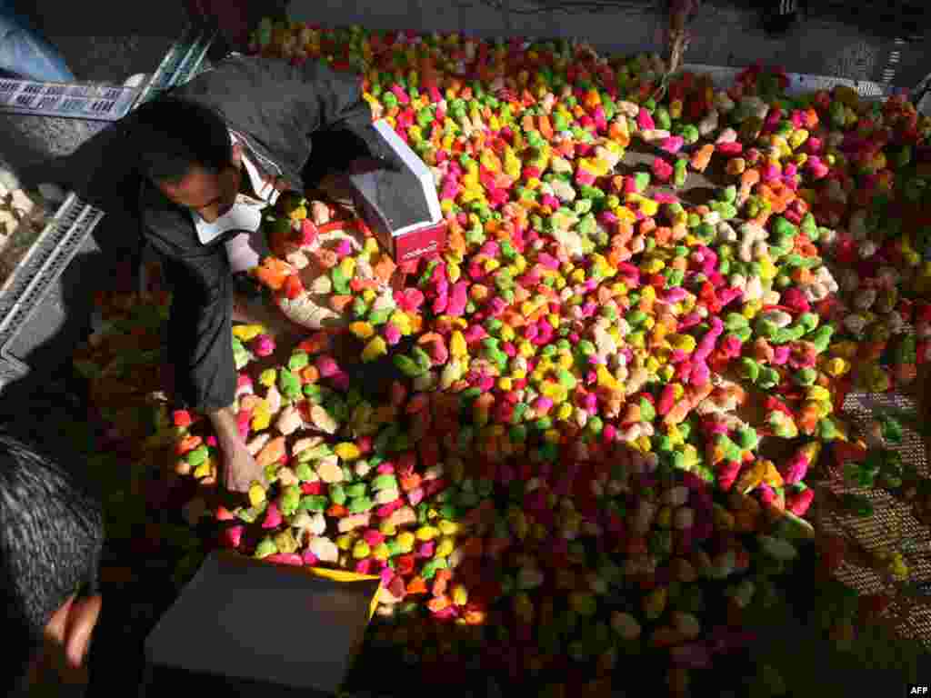 An Iraqi man sells dyed chicks at the Al-Ghazel animal market in Baghdad. - Photo by Ali al-Saadi for AFP