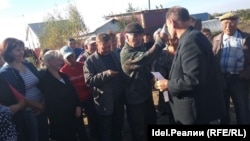 Locals remonstrate with an official in Chuvashia over plans to open a Chinese-owned dairy facility in the area. 