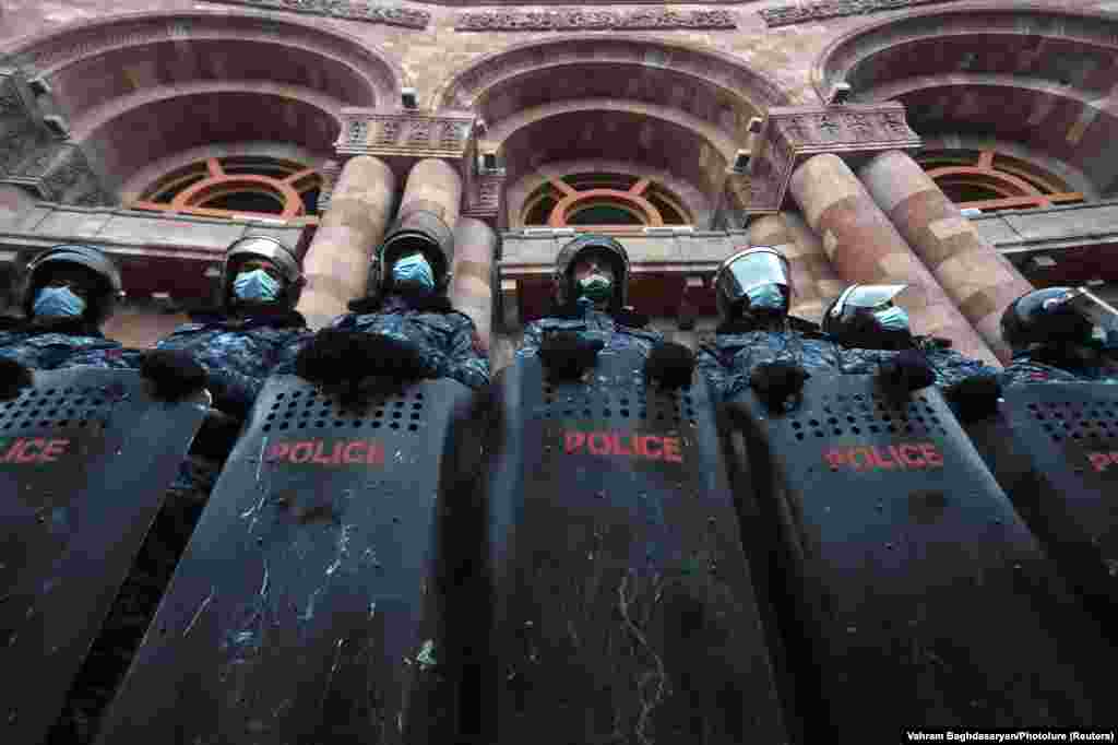 Armenian law enforcement officers stand guard outside government offices in Yerevan during an opposition rally to demand the resignation of Prime Minister Nikol Pashinian. (Reuters/Vahram Baghdasaryan)