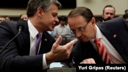 FBI Director Christopher Wray (left) and Deputy U.S. Attorney General Rod Rosenstein chat before a House Judiciary Committee hearing in Washington on June 28.