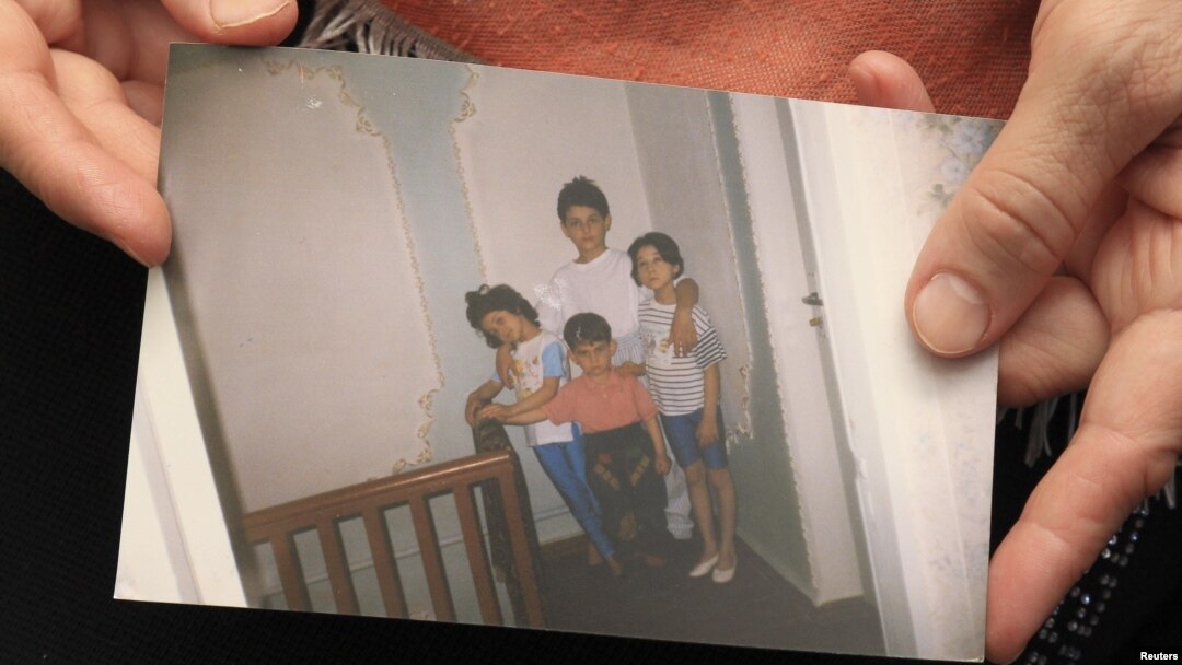 Patimat Suleimanova, an aunt of Boston bombing suspects Dzhokhar and Tamerlan Tsarnaev, holds a family photo at her house in Makhachkala showing the two as young boys .