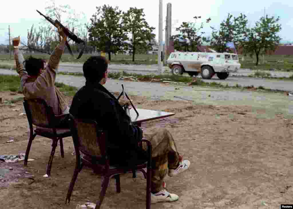 Bosnian soldiers wave to a passing UN vehicle near Sarajevo airport on May 14, 1993. The UN airlift to the Bosnian capital, called Operation Provide Promise, lasted from July 1992 to January 1996, making it the longest-running humanitarian airlift in history.