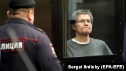 Aleksei Ulyukayev stands inside a glass defendants' cage in a courtroom of the Moscow City Court in Moscow in April 2018.