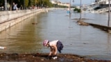 A child plays at the edge of a flooded riverside road in downtown Budapest.