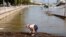 A child plays at the edge of a flooded riverside road in downtown Budapest.