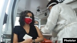 Armenia - A woman receives a coronavirus vaccine at an open-air vaccination site in Yerevan, May 7, 2021.