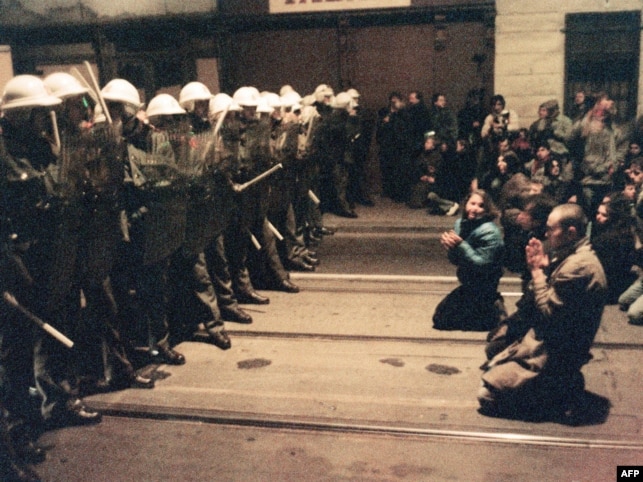 Hundreds of Czechoslovakian students kneel as they face riot police on 19 Nov 1989 in downtown Prague during a protest rally asking for more democracy and demanding the end of Communist rule.