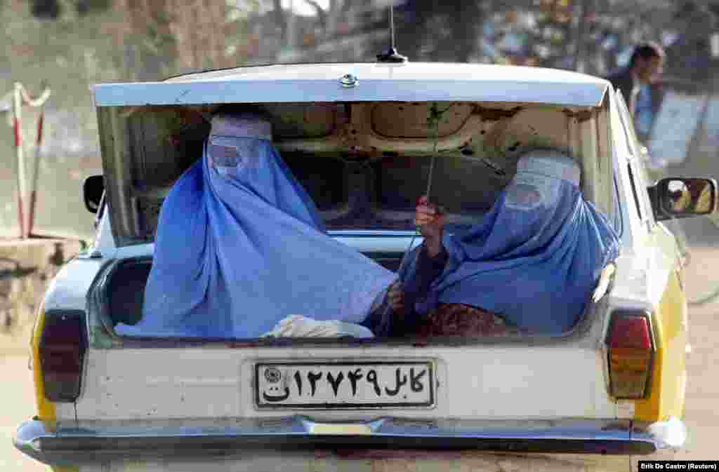 Жени со бурки се возат во багажникот на возилото. (Шарикар, 18 февруари 2003 година)