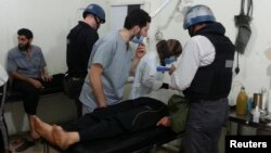 Эксперты ООН по химическому оружию в больнице Дамаска наблюдают людей, пораженных химической атакой. Сирия, 26 августа 2013 года.
