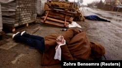 Вбитий український цивільний зі зв’язаними руками на вулиці в місті Бучі, під Києвом після того, як його залишили російські війська. 3 квітня 2022 року