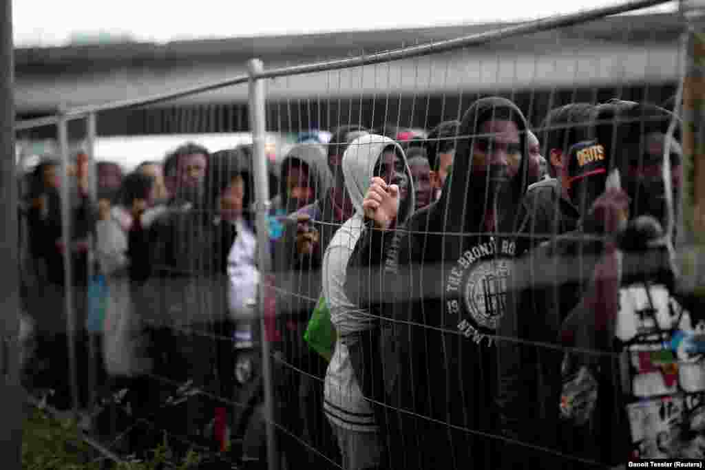 Migrants stand in line with their belongings as French police evacuate hundreds living in makeshift camps in Paris, France, on May 30. (Reuters/Benoit Tessier)