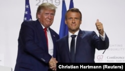 French President Emmanuel Macron shakes hands with then-U.S. President Donald Trump after a joint press conference at the end of a G7 summit in France in 2019.