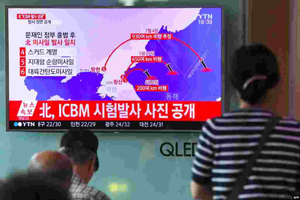 People watch a television news showing a graphic of North Korea's latest missile tests, at a railway station in Seoul on July 4. (AFP/Jung Yeon-je)