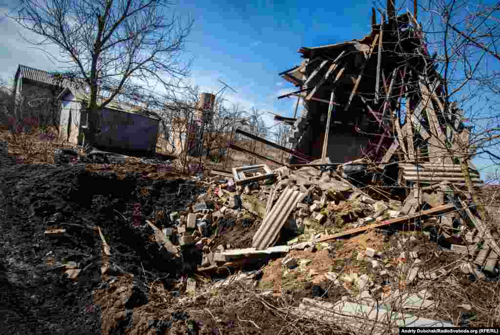 Разрушенный дом и воронка от &laquo;прихода&raquo; снаряда калибром 152-мм