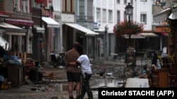 Egy pár nézi a romokat az áradás sújtotta Ahrweiler-Bad Neuenahrban 2021. július 15-én