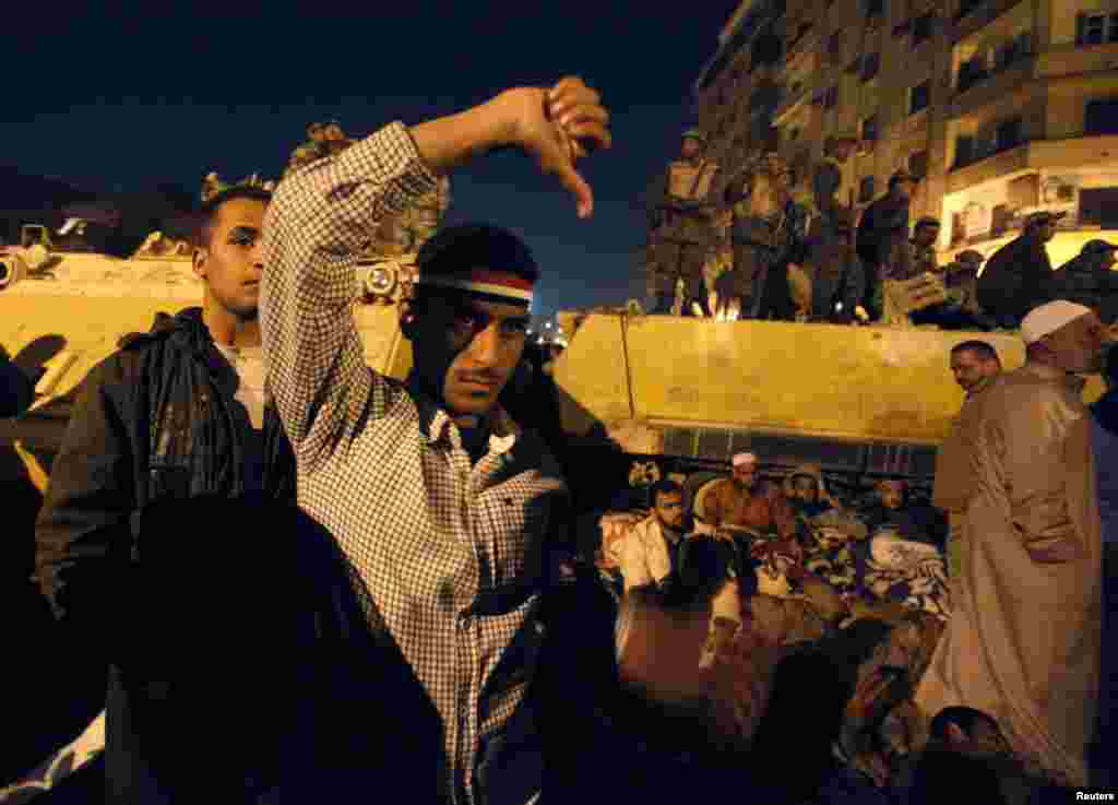 Demonstrators react as they listen to Mubarak&#39;s speech in front of a big screen in Tahrir Square on February 10, 2011.