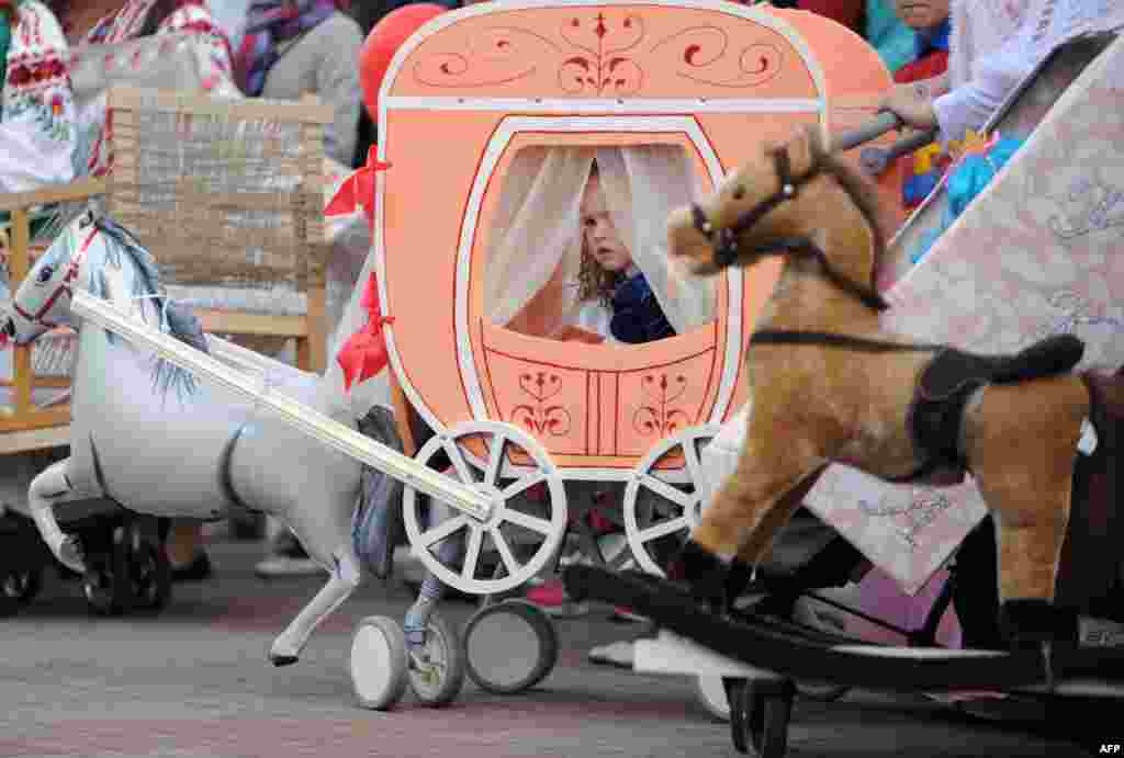 A girl looks out of her stroller decorated as a coach during a pram parade on International Children&#39;s Day in the town of Mohilev, Belarus, on June 1. (&nbsp;AFP/Sergei Gapon)