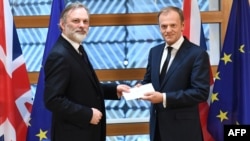 Britain's ambassador to the EU, Tim Barrow (left), delivers the formal notice of the U.K.'s intention to leave the bloc under Article 50 of the EU's Lisbon Treaty to European Council President Donald Tusk in Brussels on March 29.