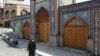 A woman wearing a protective face mask and gloves walks past the Imamzadeh Saleh shrine, amid fear of the coronavirus disease (COVID-19), in Tehran, April 2, 2020