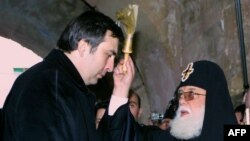 Католикос Грузии Илья II (справа) благословляет новоизбранного президента Михаила Саакашвили. Январь 2004