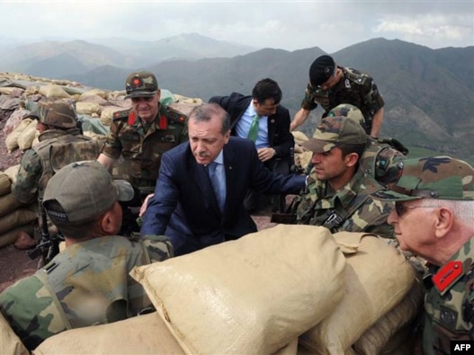 Turkish Prime Minister Tayyip Erdogan (center) talks with Turkish soldiers in a trench during his visit to the Turkish city of Hakkari on the border with Iraq on June 20.