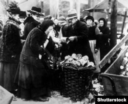 Жінка продає бляшанки на вулицях Берліна в 1923 році на тлі бідності та запаморочливої гіперінфляції