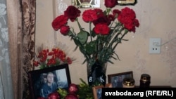 Flowers and photos of Uladzislau Kavalyou on a table in the apartment of his mother in Minsk