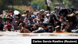 Мигранты из Центральной Америки переходят реку на границе Гватемалы и Мексики, чтобы добраться до США