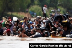 Мигранты из стран Центральной Америки, стремящиеся попасть в США, на границе Гватемалы и Мексики