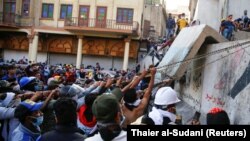 Iraqi demonstrators try to pull down concrete walls during the ongoing anti-government protests in Baghdad, Iraq November 24, 2019.