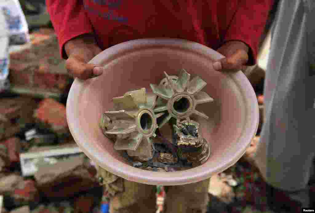 A Pakistani villager holds up a pot with fragments of mortar shells, which locals say were fired from the Indian side of the disputed border in Kashmir. 