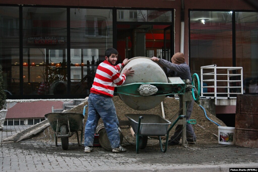 A worker in Fushe-Kosove flashes a smile at Flakon Zharku. The 17-year old photographer says he has been taking photos since he was a little boy with "whatever camera I could get my hands on."