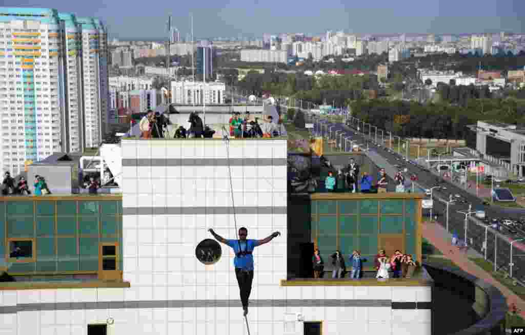 Ukrainian slackliner Stanislav Panyuta balances as he walks on a highline from the rooftop of a building in Minsk. (AFP/Sergei Gapon)