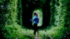 A woman stands on a disused railway track, known locally as the "Tunnel of Love," in the town of Kleven some 350 kilometers from Kyiv.