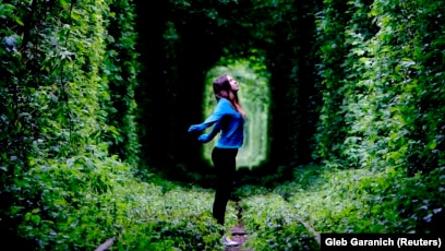 A woman stands on a disused railway track, known locally as the "Tunnel of Love," in the town of Kleven some 350 kilometers from Kyiv.