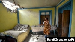 A woman shows damage to her house after shelling by Armenian forces in the Tovuz region of Azerbaijan on July 14.