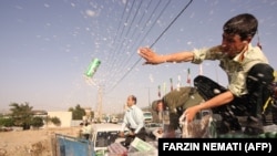 Iranian police dump confiscated beer cans in Tehran on July 22, 2009. FILE PHOTO