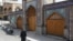 A woman wearing a protective face mask and gloves walks past the Imamzadeh Saleh shrine, amid fear of the coronavirus disease (COVID-19), in Tehran, April 2, 2020