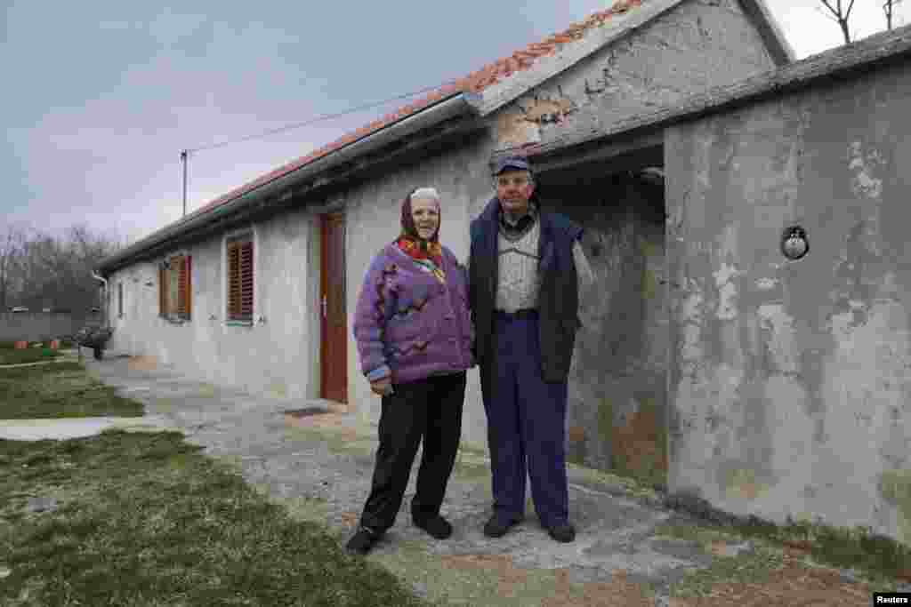 Nikola Jankovic, 83, poses with his wife, Dragonja, in the village of Bobodol, near Knin. Many of the homes nearby have been destroyed by fire and abandoned.