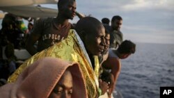 Migranții de pe puntea navei ONG-ului spaniol ProActiva Open Arms așteaptă să ajungă pe coasta Italiei de la Marea Mediterană la o zi după ce au fost salvați în largul coastei libiene. 7 septembrie 2017. 