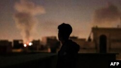 Әуе шабуылына ұшыраған жаққа алыстан көз тігіп тұрған адам. Тегеран, Иран, 2026 жылғы 4 наурыз.