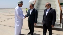 Iranian Foreign Minister Abbas Araqhchi (center) is welcomed by an unidentified Omani official upon his arrival in Muscat, Oman, for nuclear talks with the United States on May 11. 