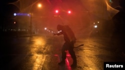  Një person në rrugët e qytetit Korpus Kristi ballafaqohet me erërat e forta të uraganit Harvey