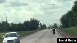 На кадре из любительского видео виден американский дрон-камикадзе Hornet, летящий на низкой высоте вдоль шоссе на оккупированной Россией территории Украины