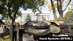 Сгоревшее авто перед зданием Жогорку Кенеша в Бишкеке. 6 октября 2020 года. 