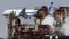 In this Thursday, Dec. 13, 2018 photo a passenger plane prepares for landing near an oil refinery in Kawasaki, southwest of Tokyo. (AP Photo/Koji Sasahara)