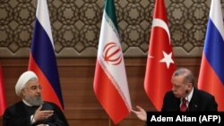 TURKEY -- Iranian President Hassan Rohani (L) and Turkish President Tayyip Erdogan gesture during a joint press conference with Russian president, as part of a tripartite summit on Syria, in Ankara, April 4, 2018